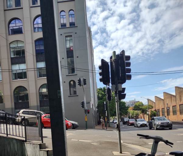 A street with traffic lights and cars on the side

AI-generated content may be incorrect.